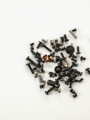 A collection of various metal screws and bolts scattered on a white background, showcasing hardware diversity.