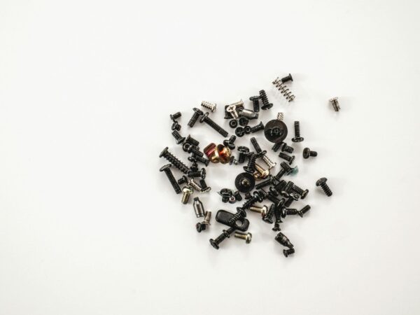 A collection of various metal screws and bolts scattered on a white background, showcasing hardware diversity.