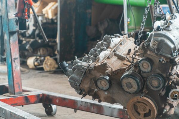 A detailed view of a car engine suspended in a workshop, perfect for automotive repair themes.